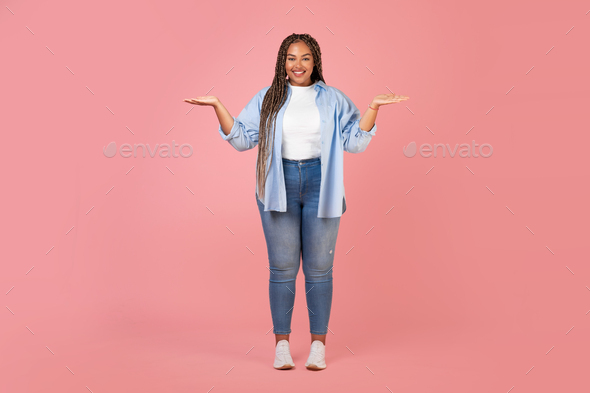 African American Lady Holding Invisible Objects On Hands, Pink Background - Stock Photo - Images
