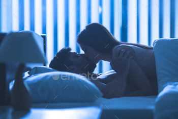 The couple kissing in the bed. night time