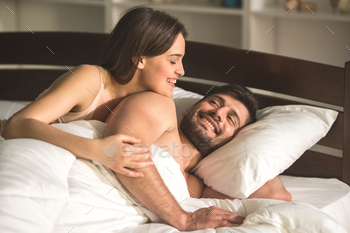 The woman hug a man in the comfortable bed