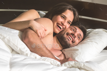 The smile woman hug a man in the comfortable bed