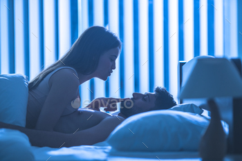 The attractive couple have a sex in the bed. night time
