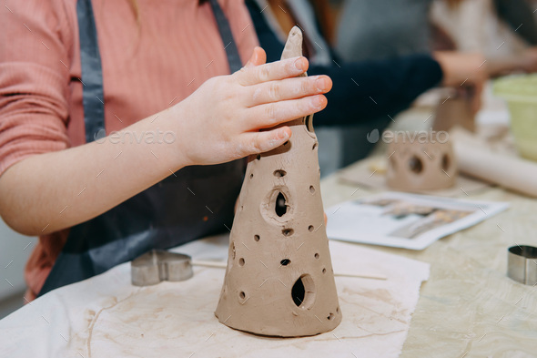 Female hands kneading clay. Production of ceramic products at the master class on ceramics.