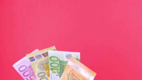 Hand in holds 50, 100, 200 and 500 EURO money bill on pink background Earning saving Eu currency 4K alt