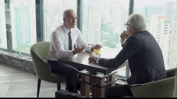 Two senior businessman discussion with partnership about work at office. alt