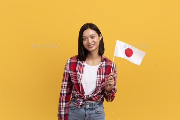 Language study and exchange student. Positive asian lady in casual holding japan flag in hand and