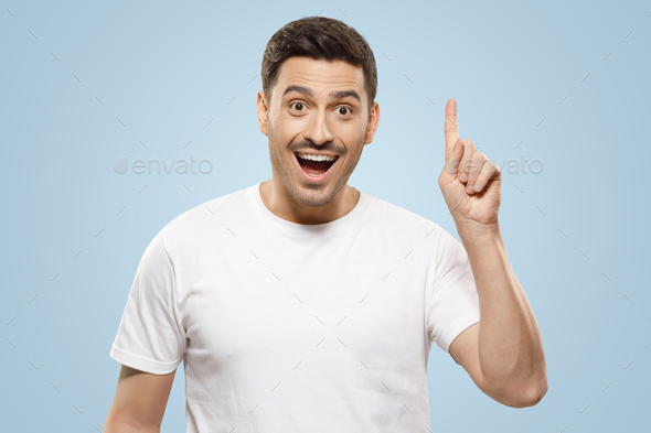 Man pointing up with finger feeling excited with open mouth, showing benefit of commercial offer