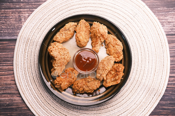 Crispy fried chicken wings on a plate top view .