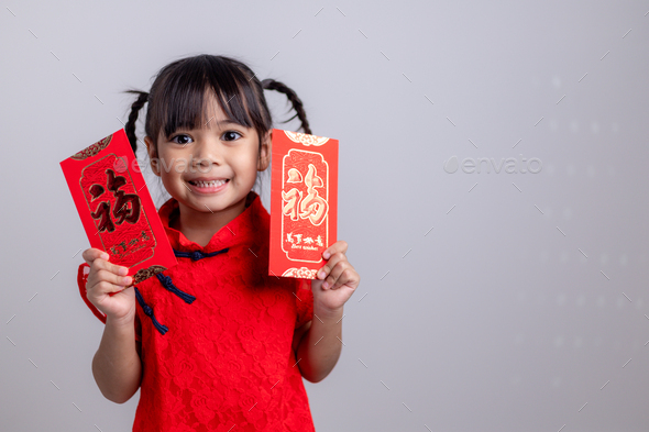 Chinese baby girl traditional dressing up with a FU means lucky red envelope - Stock Photo - Images