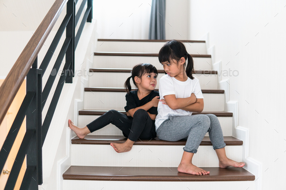 Upset siblings ignoring each other at home Stock Photo by FamilyStock