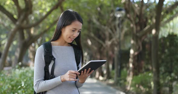 Woman use of tablet computer at outdoor park alt