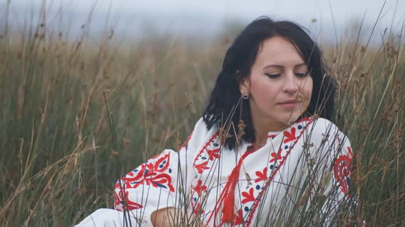 Portrait of Cheerful Charming Young Ukrainian Woman in National Clothes in Field alt