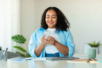 African American Business Woman Using Cellphone Sitting In Modern Office