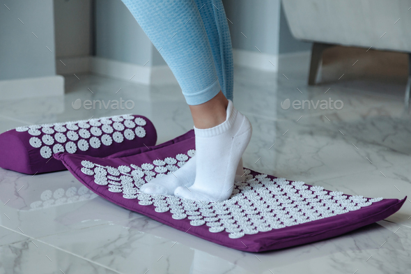Acupressure mat massage therapy. Woman feet standing on orthopedic acupressure mat for self health