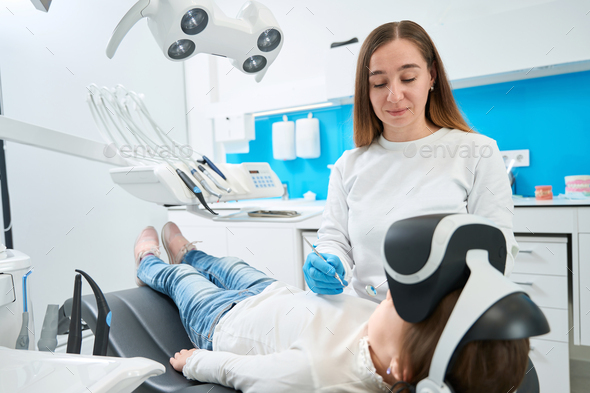 Pediatric dentist with diagnostic instruments in hands staring at ...