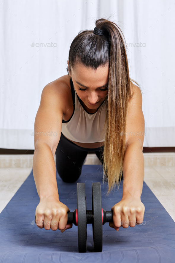 Woman doing abs exercise with roller