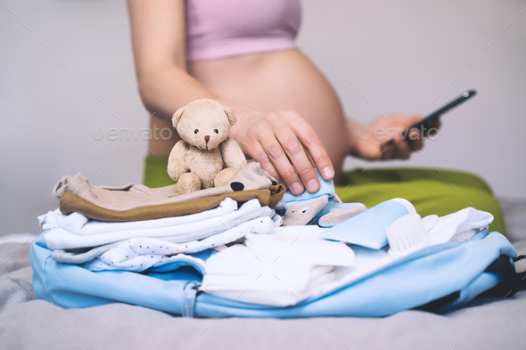 Baby clothes, necessities for mother and newborn in maternity bag.