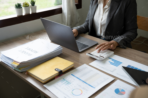Entrepreneur woman counting profit, on calculator at laptop computer, analyzing benefits, enjoying