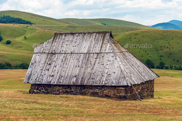 Abandoned old shepherd cottage on pasture land hill in Zlatibor region in Serbia - Stock Photo - Images