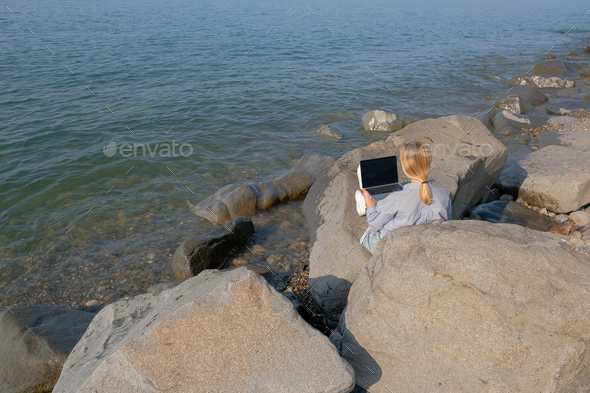 Remote work.Girl freelancer works remotely on the sea shore.workation, remote work,WFVH,Van Life vib