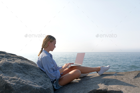 Remote work.Girl freelancer works remotely on the sea shore.workation, remote work,WFVH,Van Life vib