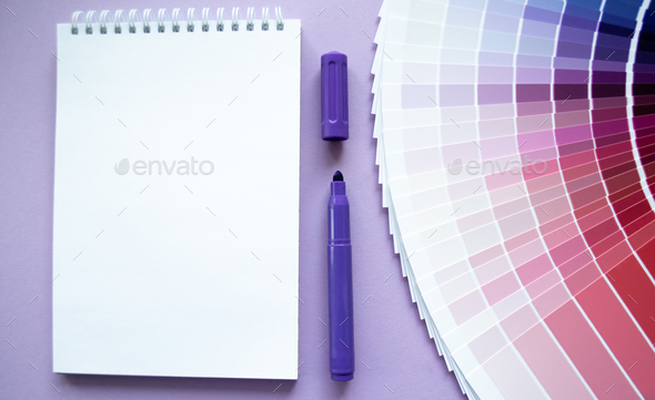 Paint samples, multicolors swatch for design. Lilac background, notebook, purple marker. Copy space