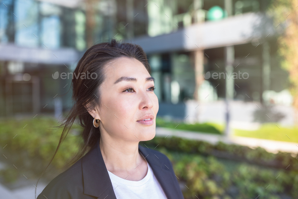 Asian confident business woman in suit smiling, looking up. Job, work aspirational banner copy space