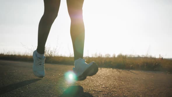 Close Up of Women's Legs Running on Asphalt Road alt