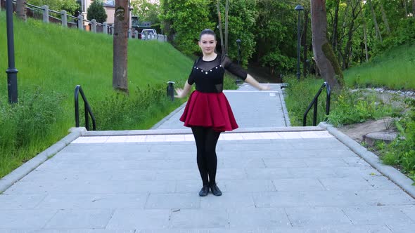 Stunning female dancer dances outside in the park alt