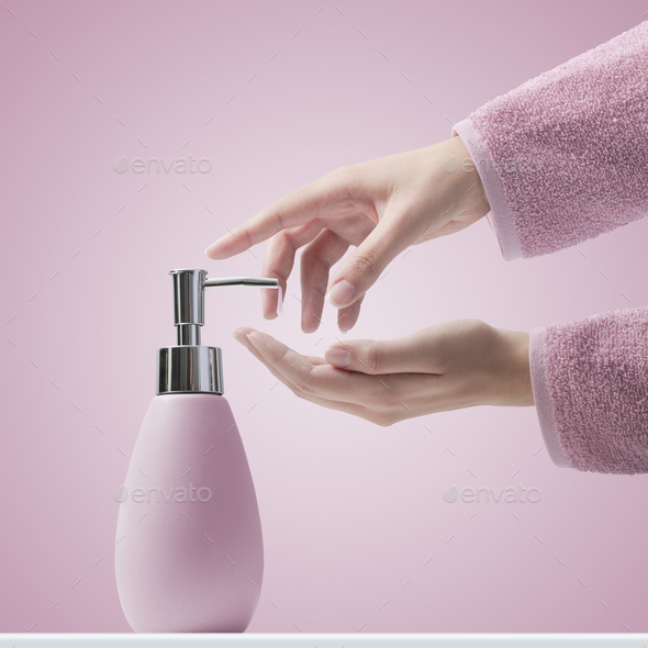 Woman pumping soap on her hands - Stock Photo - Images