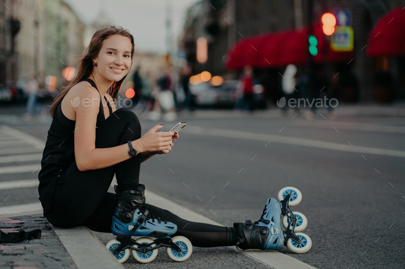 active slim woman being in good physical shape rides rollerblades