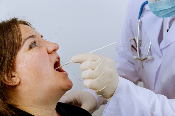 Medical worker to check in woman on mouth swab for PLR test coronavirus for Covid-19
