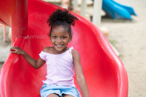 Little Girl Sliding Down Playground Slide Stock Photo, Picture and