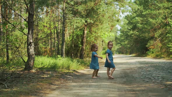 Girls are Walking on a Forest Road