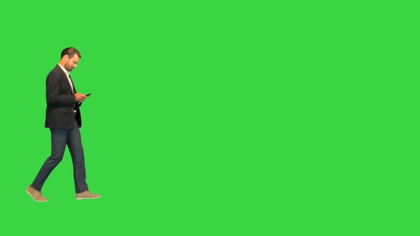 Businessman Using Smartphone While Walking By on a Green Screen Chroma Key alt