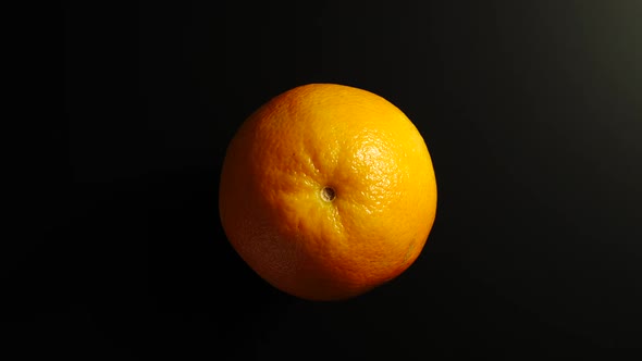 Orange Rotates On A Black Surface