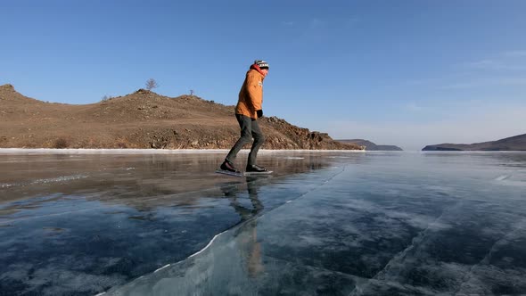 Young Man Ice Skating on Beautiful Baikal Lake, Russia