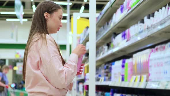 Woman is Sniffing Deodorant in Supermarket Shopping alt