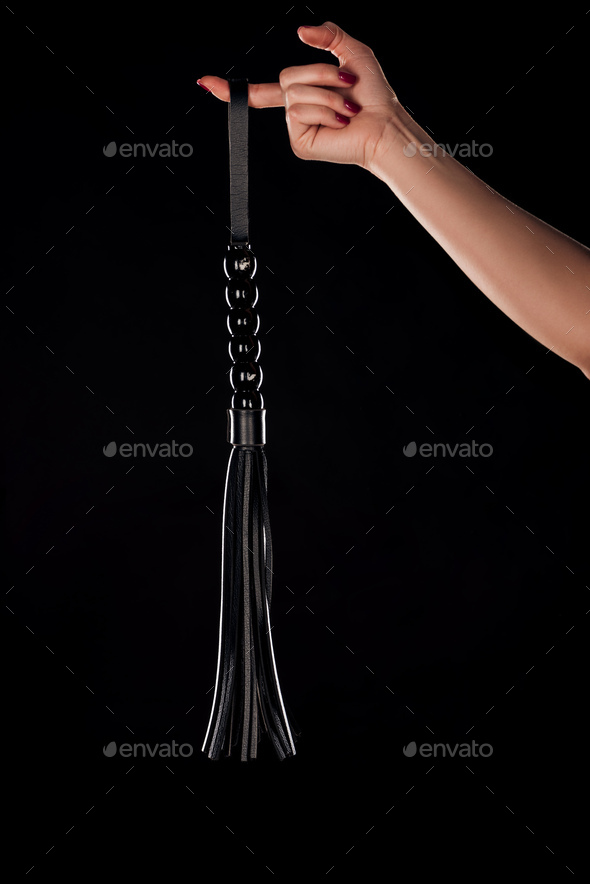 partial view of woman holding leather flogging whip on finger isolated on black  Stock Photo by LightFieldStudios