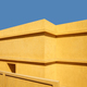 Yellow building wall against the blue sky. - PhotoDune Item for Sale