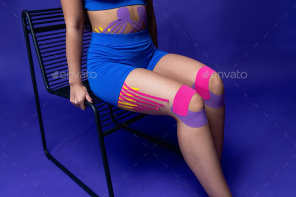 knee joint fixed with kinesiological tape, close-up. Taping muscles and ligaments in sports