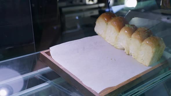Professional Male Baker with Gloves Spreads Fresh, Fragrant Hot Bun Made From Wheat Flour on Board alt