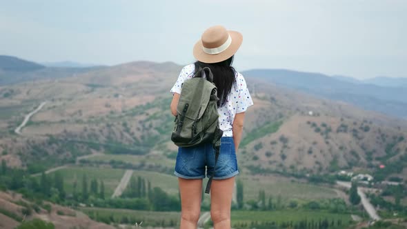 Back View Backpacker Woman Admiring Nature with Mountains and Sea alt