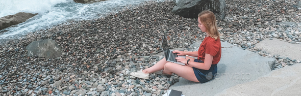 Remote work.Girl freelancer works remotely on the sea shore.workation, remote work,WFVH