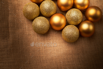 golden christmas balls with different textures and glitters on sackcloth