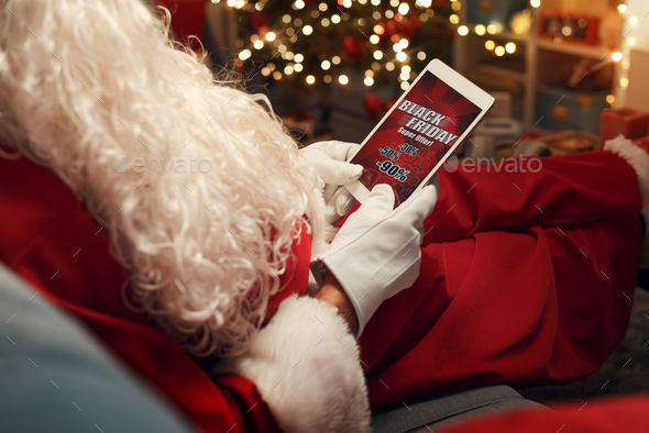 Santa Claus watching a Black Friday sale advertisement