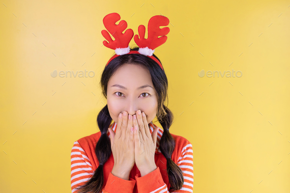 Photo of an excited asian girl in a Christmas sweater, pullover, deer, headband, new year time, winn