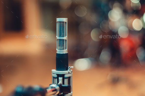professional condenser microphone isolated from a rehearsal room blurred in the background