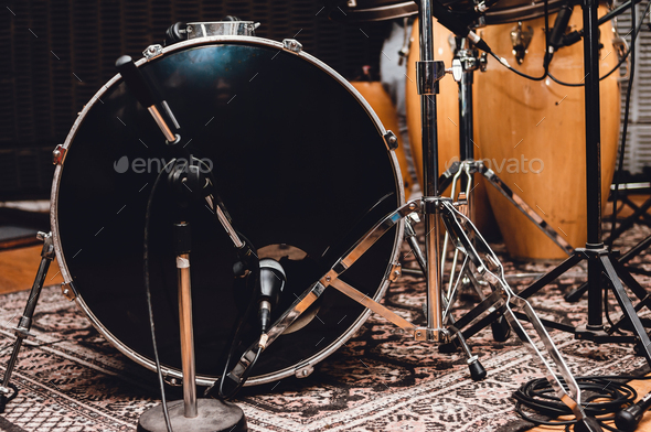 front view of a bass drum with professional recording microphones, in a music studio