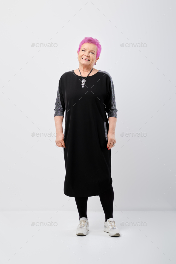 Active old woman with pink hair in a jersey dress