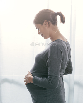 Happy pregnant woman posing at home